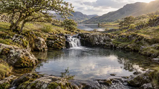 A calm glassy pool lies below a cascade with a quiet smooth outflow slipping from its lower edge into the next reach with reflected sky and overhanging hawthorn branches in still grey light.