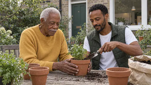 A tall elderly man holds a clay pot steady while a younger bearded neighbour in a green vest pats compost into it with a trowel at a wooden garden table with empty pots and a bag of compost in soft green light.