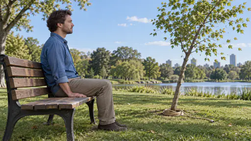 Sitting on your hands: an adult sits squarely on both hands on a park bench, palms extending beneath the thighs, while a loose rope beside them could steady a wobbling young tree.