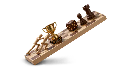 An uphill battle: two small wooden mannequin workers lean into a steeply tilted chessboard, pushing a gold wheeled trophy upward while large dark game pieces slide down toward them — progress requires fighting an unfavorable situation.