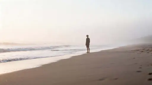 A lone figure stands barefoot at a calm, empty beach shrouded in soft morning fog with gentle waves kissing the shore and pastel tones rendered in realistic photographic detail.