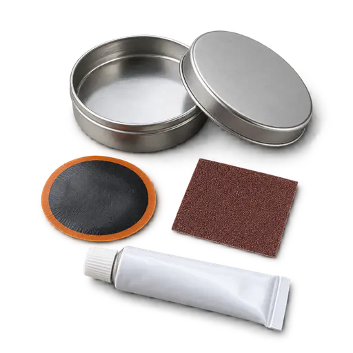 A small round tin open beside a rubber patch, a piece of sandpaper and an unmarked glue tube, a bicycle puncture patch kit with a soft contact shadow, on a transparent background.