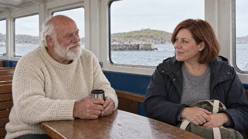 A broad white-bearded man in a cream fisherman's jumper holds a thermos cup and a woman with a chin-length auburn bob and a canvas bag on her lap chat across a narrow wooden table in the cabin of a small ferry in warm window light.