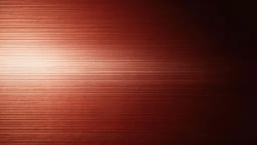 Studio product photograph (16:9) of a subtle brushed red metal surface with fine horizontal grain, soft directional highlights fading into deep shadow and a clean negative space.
