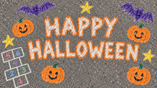 A wax crayon drawing on grey pavement: HAPPY above HALLOWEEN in big white letters outlined in orange, with smiling jack-o-lanterns, purple bats, yellow stars and a hopscotch grid numbered one to six.