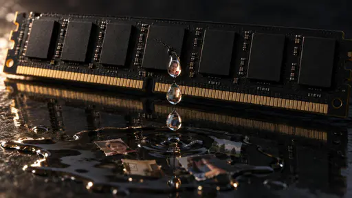 Memory leak: a macro view of a black computer memory module lying across a dark reflective surface, its row of chips unlabelled. A single hairline crack splits one chip's casing, and from it clear droplets fall, each bead enclosing a tiny fragment of a family photograph. A shallow puddle spreads…