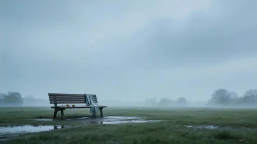 Cinematic 16:9 widescreen of a solitary wet park bench off-center after rain, with low horizon, heavy overcast sky, a damp leaf or forgotten scarf, and soft haze.