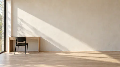 A bare warm plaster wall in a sunlit studio with a minimal oak desk and a black chair at the lower left on a pale wooden floor, a diagonal band of window light across the wall and a large clear area above and to the right.