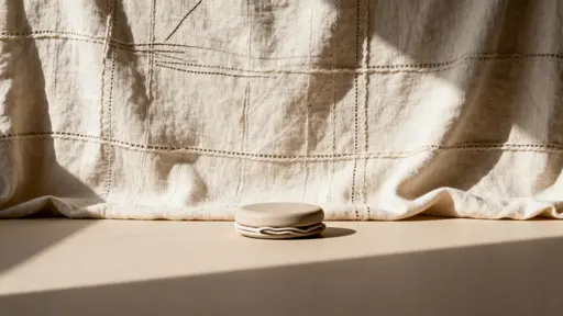 A fabric-like background lit by shallow, directional light that sculpts gentle folds and subtle texture, composed and cropped specifically for a cinematic 16:9 frame.