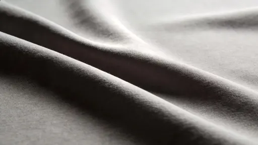 Monochrome study of fabric folds photographed as a widescreen 16:9 composition for wallpaper, emphasizing sculptural texture, soft shadows, and serene minimalism.