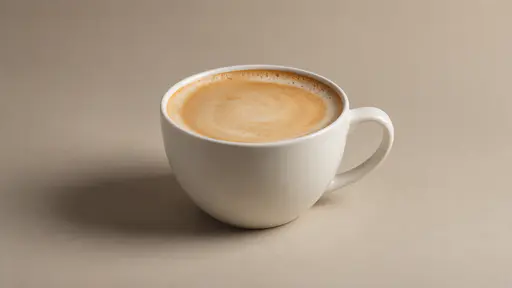 One plain latte cup in gentle side light shows its foam settled flat against the inner rim with one thin pale ring of foam at the edge.
