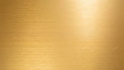 A flat, straight-on champagne gold brushed-metal background with horizontal micro-scratches and soft warm highlights, offering wide clean areas for logos.