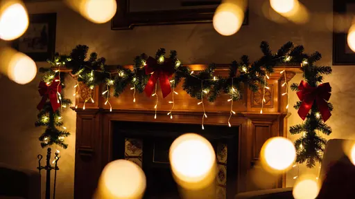 House facade and nearby trees framed in a 16:9 wide view at dusk, bathed in slightly dark ambient light and warm glowing fairy lights for a cozy evening holiday mood.