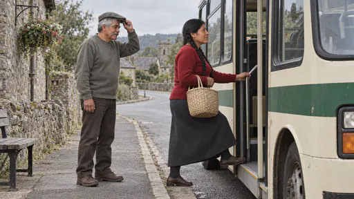 A woman with two long black braids in a red sweater steps up into the open door of a small cream and green rural bus with a woven basket on her arm while an elderly man with a grey moustache in a flat cap waits behind her lifting his cap.