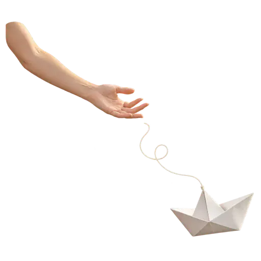 Letting go — an adult hand opens to release a small origami paper boat that drifts away on a loose white thread, picturing the meaning of letting go: releasing a bond, burden, or the need to control.