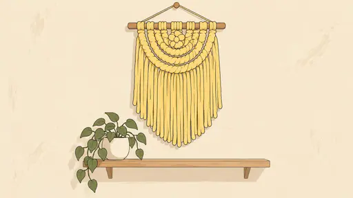 A neatly coiled pastel yellow macrame wall hanging with long soft fringe hangs on a blank cream wall above a small plant on a wooden shelf.