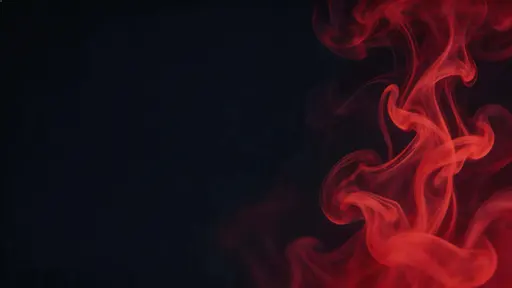 16:9 abstract fluid photograph of red ink swirling through dark liquid into marble-like ribbons and soft tendrils, with the most intricate swirl off-center and a clean darker region for negative space.