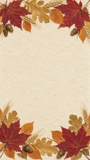 A tall cream handmade paper card background with pressed red maple, gold oak and orange leaves, small acorns and wheat stalks along the top and bottom edges, overlapping at the corners, and a large blank centre.