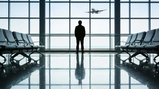 A modern airport interior showing a lone traveler silhouetted against expansive window glass, watching an aircraft glide under a cool gray-blue sky with polished reflective floors.