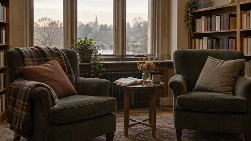 A public library window bay holds two deep armchairs and a small side table with an open blank book and reading glasses in low gold window light.