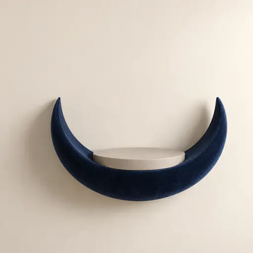 A square studio photograph of a thick midnight-blue velvet crescent moon shelf mounted on a warm cream wall, cradling a flat empty round plaster base at its centre, with soft side light, one gentle shadow and a clean upper-left wall area kept free for a product and headline.