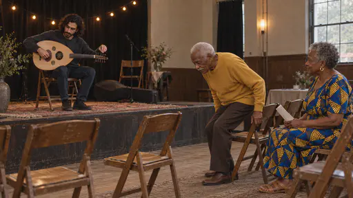 A slim bearded musician tunes an oud on a low stage while a tall elderly man in a mustard sweater and an older woman in a blue and yellow wax-print dress take folding chairs in the front row in warm early-evening light.
